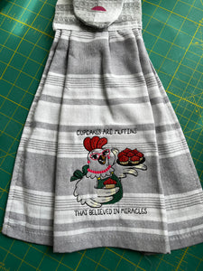 Over the door hanging towel.  "Cupcakes are muffins that believed in miracles"