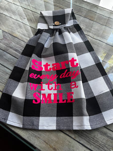 Over the door hanging towel.  " Start everyday with a smile"